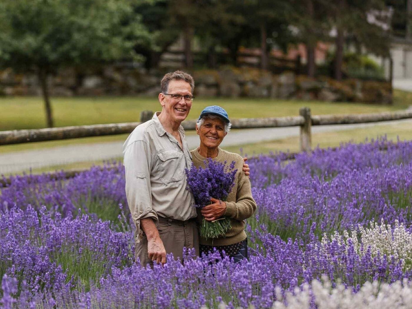 The owners of Tolt Hill Family Farm holding a bouquet of fresh-cut lavender in their field